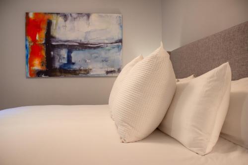 a bed with two pillows and a painting on the wall at Douglas On Third in McMinnville