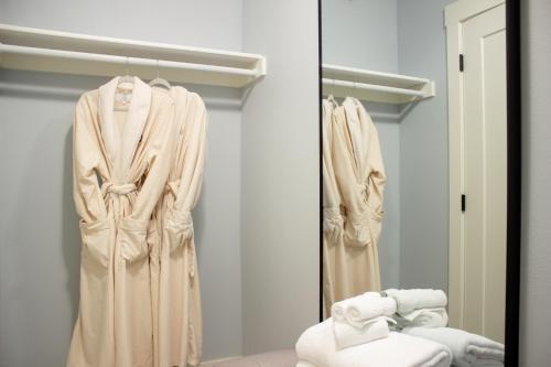 a dressing room with a robe and a mirror at Douglas On Third in McMinnville