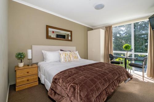a bedroom with a bed and a table and a window at Sunny Apartment Methven in Methven