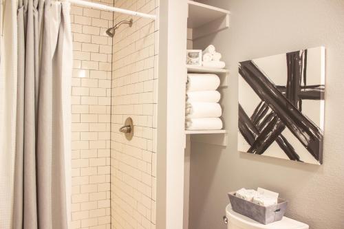 a bathroom with a shower and a toilet with towels at Douglas On Third in McMinnville