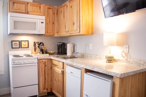 a kitchen with white appliances and wooden cabinets at Douglas On Third in McMinnville
