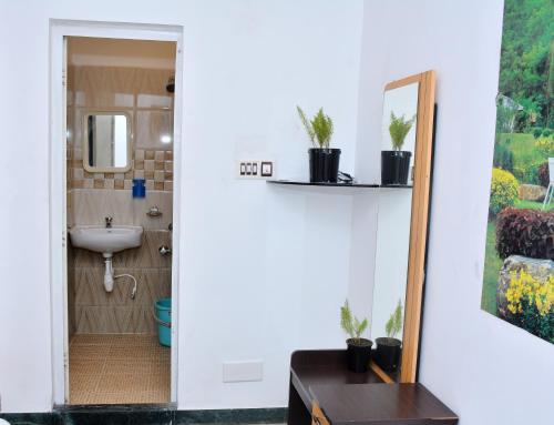 uma casa de banho com um lavatório e um espelho em TGT Holidays Yercaud em Yercaud