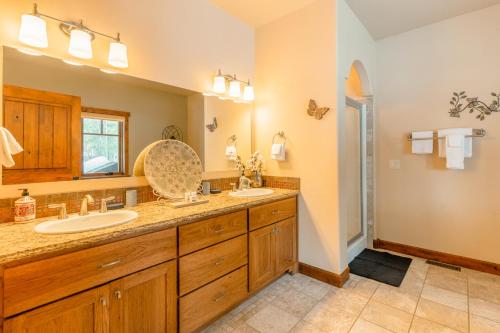 baño con 2 lavabos y espejo grande en Pine Place en Kalispell