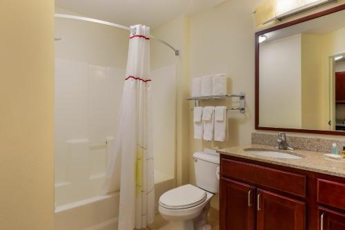 a bathroom with a toilet and a sink and a shower at MainStay Suites Fitchburg - Madison in Madison