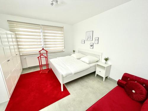 - une chambre avec un lit blanc et un tapis rouge dans l'établissement Wohnung in Kassel mit Ladesäulen, à Cassel