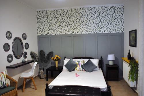 a bedroom with a bed and a patterned wall at Verde rete apartments2 in Áno Stavrós
