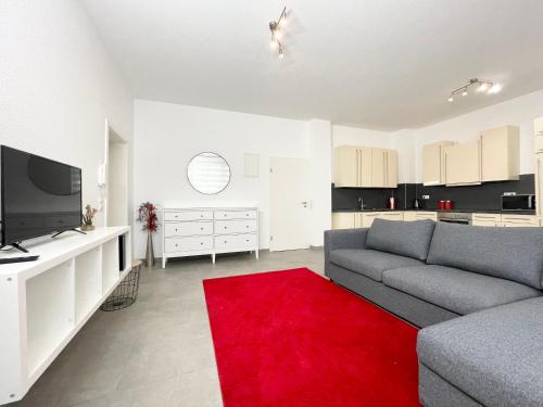 - un salon avec un canapé et un tapis rouge dans l'établissement Wohnung in Kassel mit Ladesäulen, à Cassel