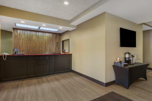 a waiting room with a bar and a tv on the wall at MainStay Suites Fitchburg - Madison in Madison