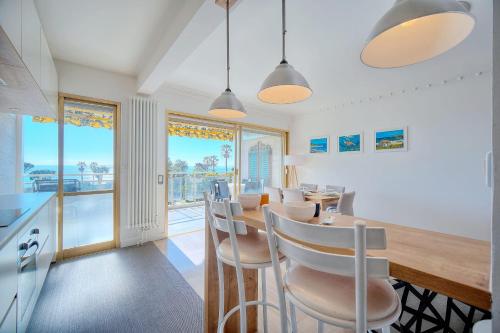 une cuisine et une salle à manger avec une table et des chaises dans l'établissement IMMOGROOM - Fully equipped - Terrace - Pool - Wifi - Air conditioning, à Cannes
