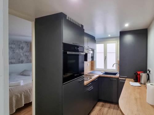 une cuisine avec un évier et une cuisinière four supérieur dans l'établissement Travel Homes - NewGate 1, elegant, heart of Colmar, à Colmar