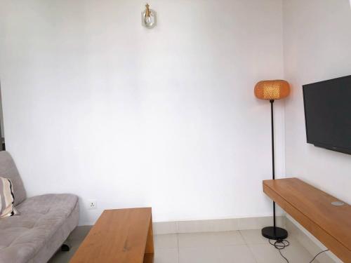 a living room with a couch and a flat screen tv at Ptas Tauch Residence in Phnom Penh