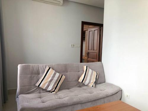 a couch with two pillows sitting in a room at Ptas Tauch Residence in Phnom Penh
