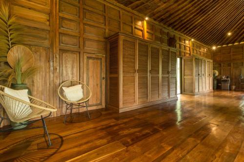 an empty room with a chair and wooden walls at Masakali Retreat in Ubud