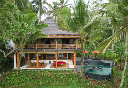 a villa with a swimming pool and a house at Masakali Retreat in Ubud