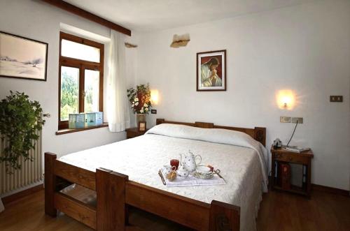 a bedroom with a bed with a tray of food on it at Albergo Piani di Luzza in Forni Avoltri