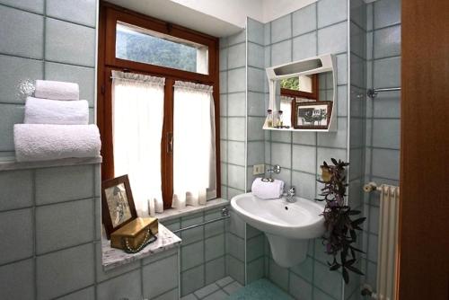 a bathroom with a sink and a window at Albergo Piani di Luzza in Forni Avoltri