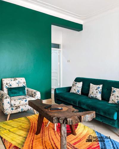 - un salon avec un canapé vert et une table basse dans l'établissement Green mona unit, à Kampala