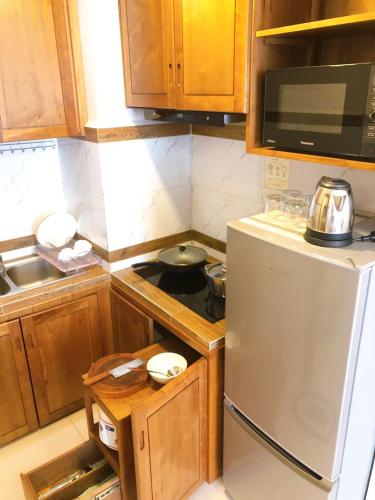 a kitchen with a stove and a white refrigerator at Ptas Tauch Residence in Phnom Penh