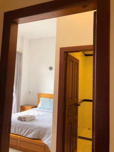 a bedroom with a bed and an open door at Ptas Tauch Residence in Phnom Penh