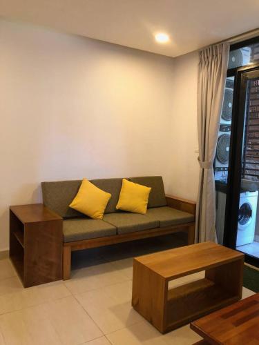 a couch with two yellow pillows in a living room at Ptas Tauch Residence in Phnom Penh