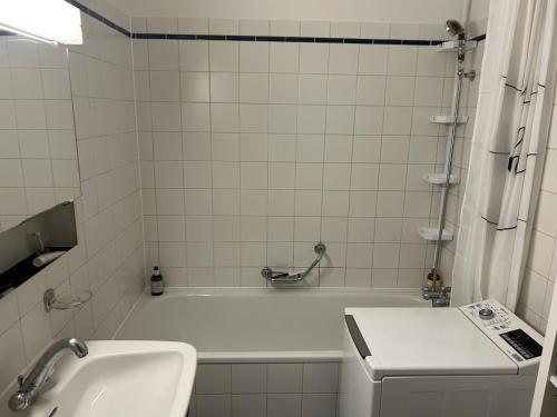 uma casa de banho com uma banheira branca e um lavatório. em Chambre, bedroom - Perle du Lac, Geneva em Genebra