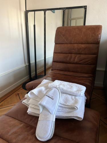 une pile de serviettes assises sur une chaise dans l'établissement Chambre, bedroom - Perle du Lac, Geneva, à Genève