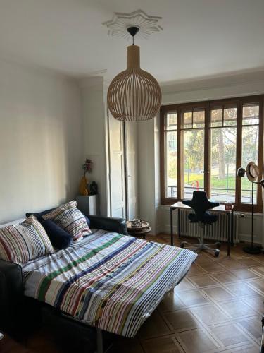 Schlafzimmer mit einem Bett, einem Schreibtisch und einem Kronleuchter in der Unterkunft Chambre, bedroom - Perle du Lac, Geneva in Genf