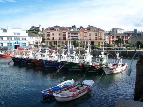 a group of boats are docked in a harbor at HAVANAAPARTAMENTOS in Puerto de Vega