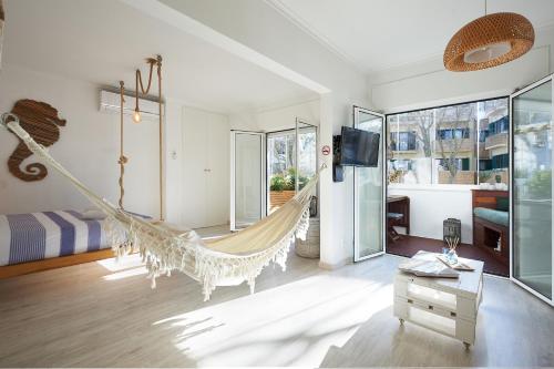 a bedroom with a hammock in a room with a bed at Cozy Beach House São Pedro Estoril in São Pedro do Estoril