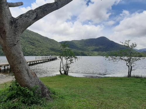 a large body of water with a pier and a mountain at Casa do Porto - a 600m do Mar e da Lagoa in Florianópolis