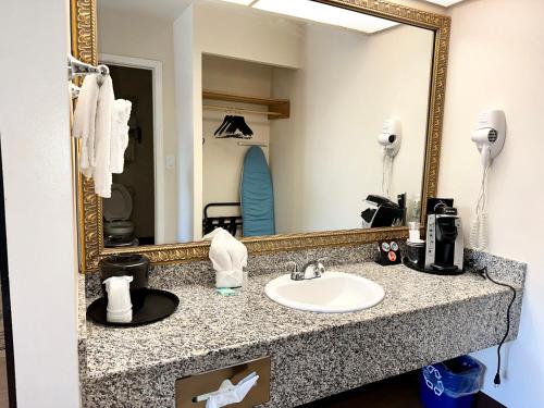 a bathroom with a sink and a mirror at Stanford Inn & Suites Anaheim in Anaheim