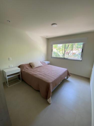 Un dormitorio con una cama grande y una ventana en Freja II - Huaico - Departamento entero con balcón y asador en San Salvador de Jujuy