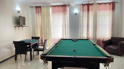 um quarto com uma mesa de bilhar e uma sala de jantar em Lao Tangren Guest House em Kigali