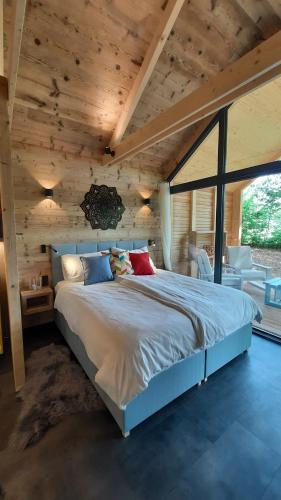 uma cama grande num quarto com tecto em madeira em Forest Garden Romance 