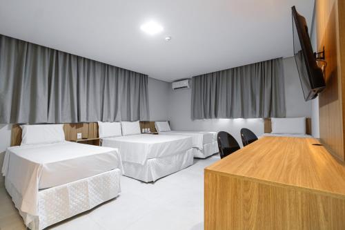 a hotel room with two beds and a flat screen tv at Hotel Solar Paulista in Sao Paulo