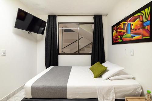 a bedroom with a bed and a window at Hotel Balcones del Estadio in Medellín