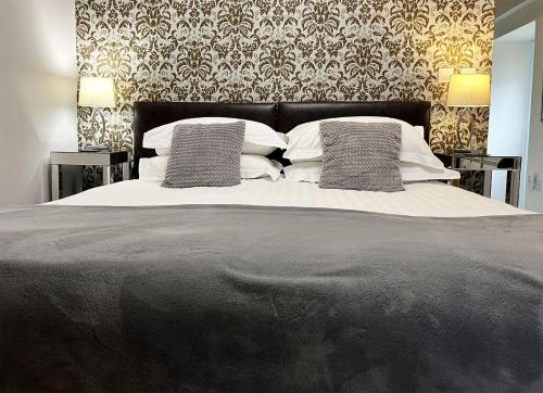 ein Schlafzimmer mit einem großen Bett mit zwei Kissen in der Unterkunft Mill House Cottage, Fishing Park, Brampton, Nr Carlisle in Brampton