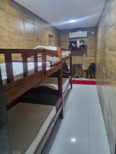 a room with three bunk beds and a chair at Recanto Convenções in Olinda