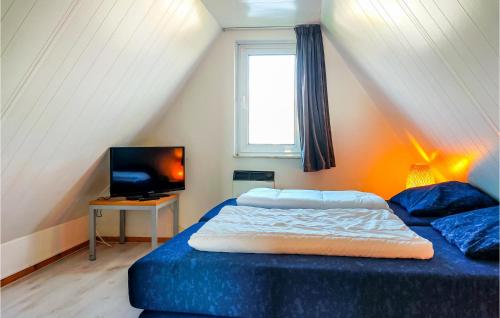 um quarto com uma cama azul e uma televisão em Amazing Home In Gramsbergen With Kitchen em Gramsbergen