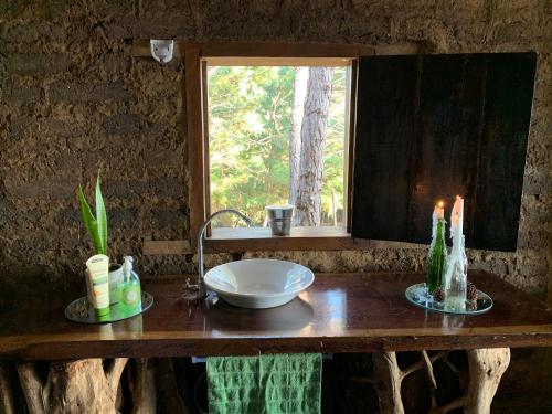 a bathroom counter with a sink and a window at Cabaña Tamanique in Tamanique