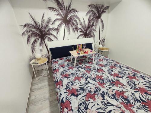 Schlafzimmer mit einem Bett mit Palmen an der Wand in der Unterkunft Sweet Apt Charco by flamingo house in Arrecife