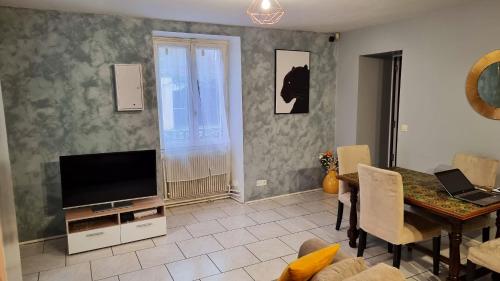 ein Wohnzimmer mit einem TV und einem Esstisch in der Unterkunft Maison de 3 chambres avec terrasse et wifi a Saint Michel sur Orge in Saint-Michel-sur-Orge