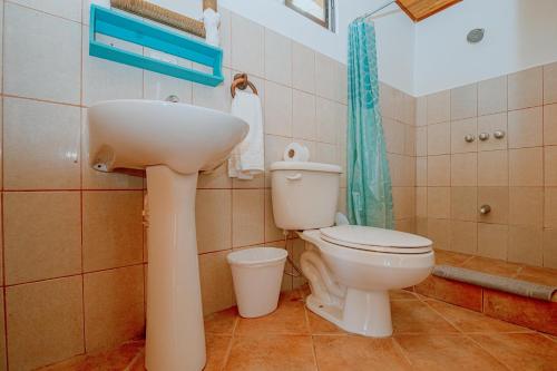 a bathroom with a white sink and a toilet at Hotel Planeta Sano in Manuel Antonio