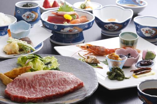 a table with plates of food and bowls of food at Oyado Hachibei in Takayama