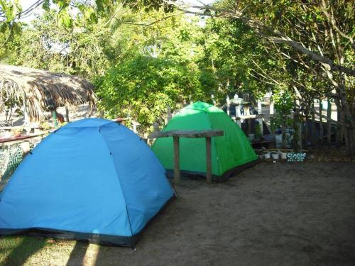 Tienda azul y verde, mesa y árboles en Camping Casa Mágica-Taipu de Fora en Barra Grande