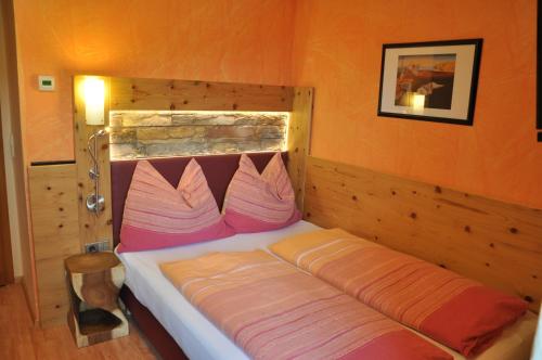 a bedroom with a bed with an orange wall at Himmelsbögen und Apartments mit Seeblick und Alleinlage in Weissensee