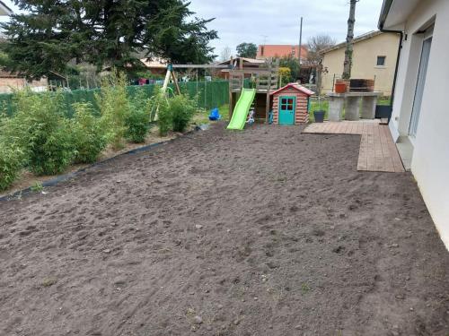um quintal sujo com um parque infantil num quintal em Maison au calme em Belin-Beliet