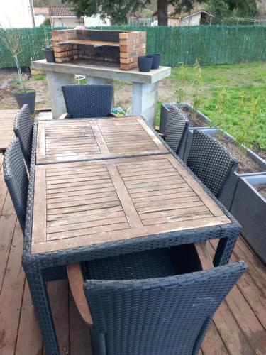 una mesa de madera y sillas en una terraza en Maison au calme, en Belin-Beliet