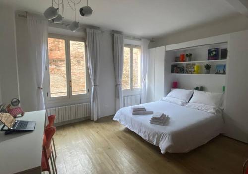 ボローニャにあるAppartamento San Feliceのベッドルーム(白いベッド1台、ノートパソコン付きのデスク付)