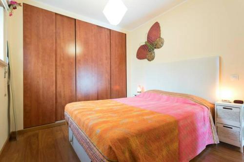 a bedroom with a bed and a butterfly on the wall at Cosy apartment with terrace in Alcabideche